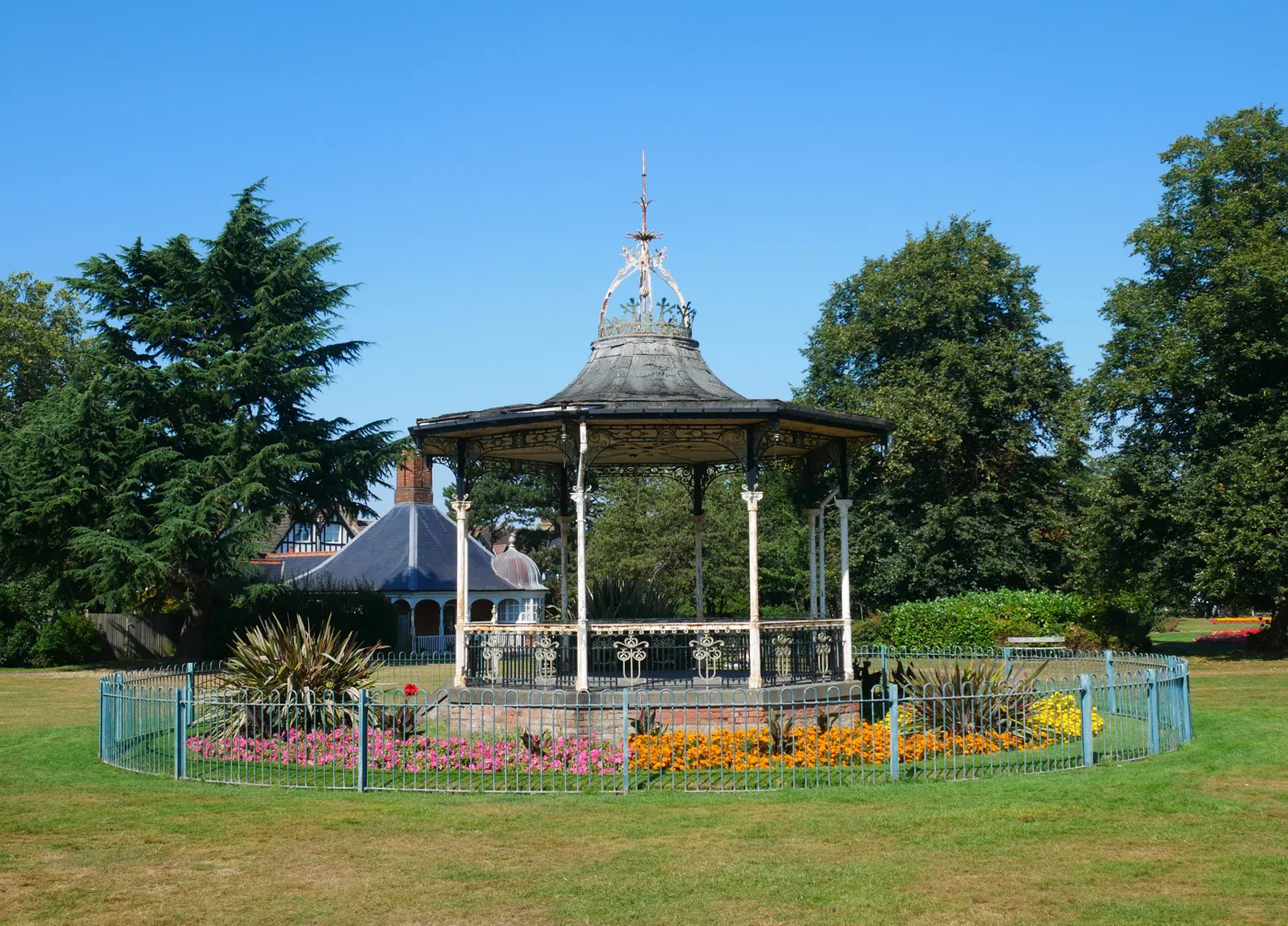 The white Victorian bandstand in Croydon Road Recreation Ground, Beckenham, ringed by flower beds and railings