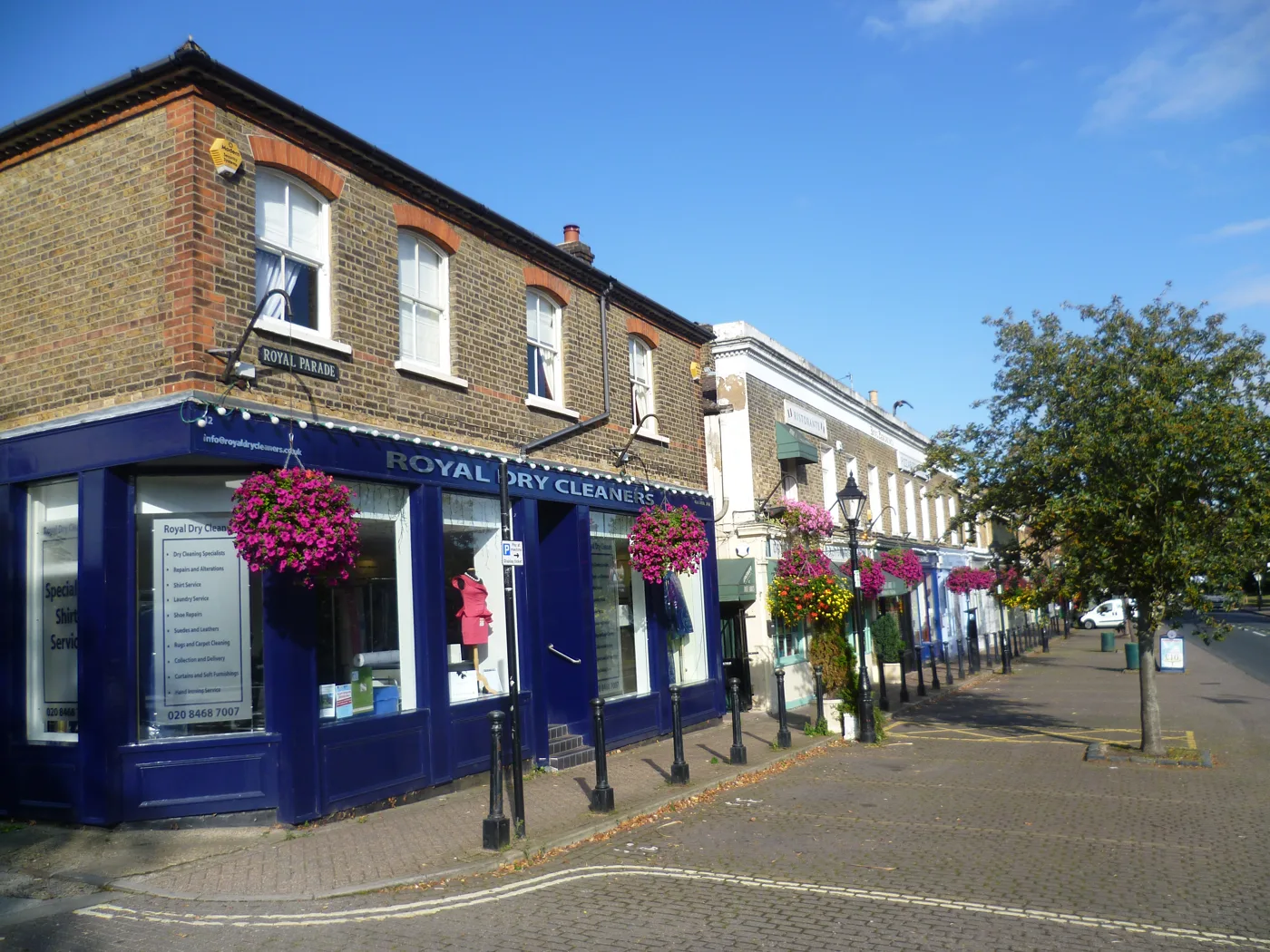 Shops on Royal Parade, Chislehurst, with hanging baskets along the pavement